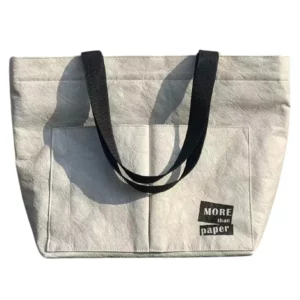 Saco de papel Dupont branco com pegas pretas e texto no bolso da frente