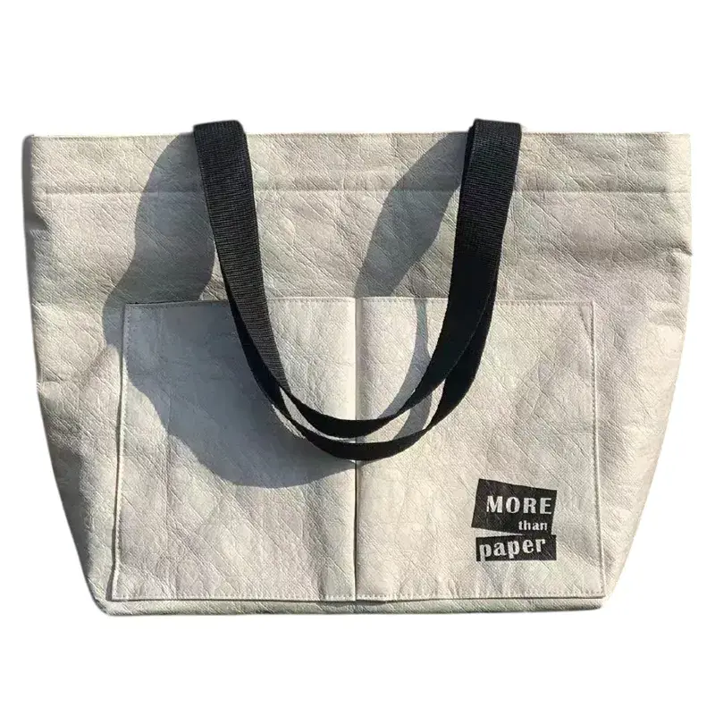 Saco de papel Dupont branco com pegas pretas e texto no bolso da frente